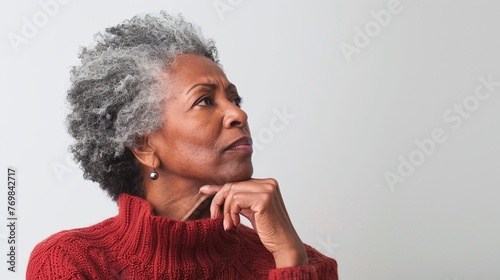 confident senior African American woman imagining something, touching chin, being deep in thoughts, isolated on white background with copy space
