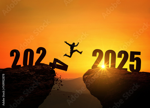 Man jumping on cliff 2025 over the precipice with stones at amazing sunset. New Year's concept. 2024 falls into the abyss. Welcome 2025. People enters the year 2025, creative idea.