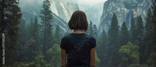 A woman with facing away from the camera with mountain in the background.