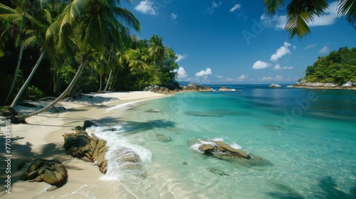 A secluded beach with turquoise water, white sand, and swaying palm trees. 