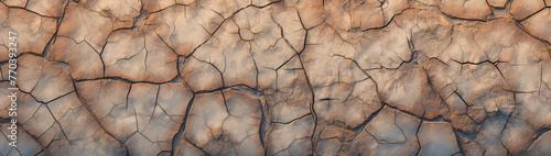 Aerial perspective of a cracked, dry riverbed in a desert expanse.