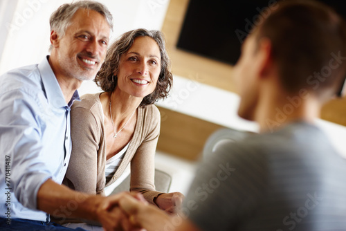 Senior couple, smile and person with handshake for loan agreement, insurance policy and decision in living room. Man, woman and hand with gesture for deal, consultation and planning for retirement