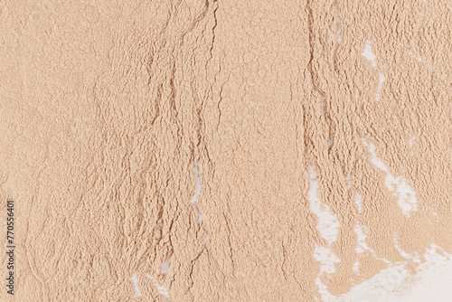 Delicate loose texture of cosmetic powder in a natural tone. Close-up view. Cosmetic background for design, product mockup.