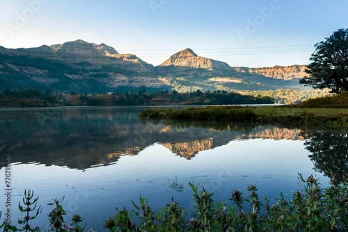 Scenic view of Arthur Lake in Bhandardara, India is seen, with lush green hills and trees