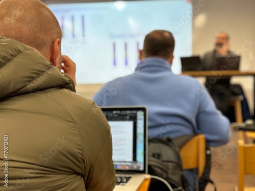 The process of training young businessmen. Students sit in class and listen to the teacher. Students with computers at desks in class, background blurred. Lviv, UBTS Seminary, November 7, 2023