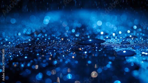  A tight shot of a raindrop atop a surface against a backdrop of blue lights, accompanied by additional raindrops on said surface