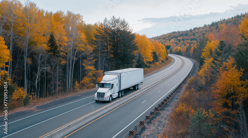 White semi truck on highway with vibrant fall foliage