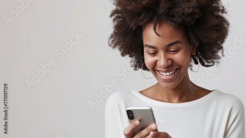 An African American woman grins while using her smartphone, evoking the pleasure of digital connectivity in everyday life