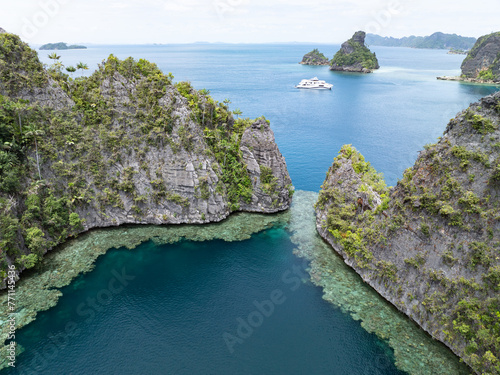 The limestone islands of Balbalol, fringed by reef, rise from Raja Ampat's tropical seascape. This region is known as the heart of the Coral Triangle due to the high marine biodiversity found there.