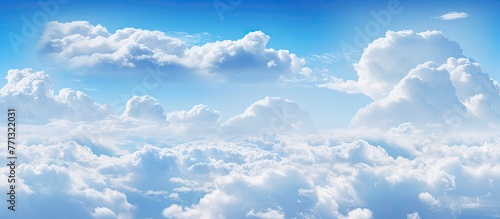 An airplane gracefully gliding high up in the sky amidst billowy volumetric cumulus clouds against a serene blue background