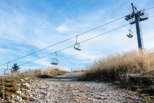 Empty ski lift above a rocky hillside landscape