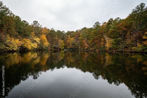 Lush fall forest mirrored in crystal clear Sibley Pond waters, Marietta, GA