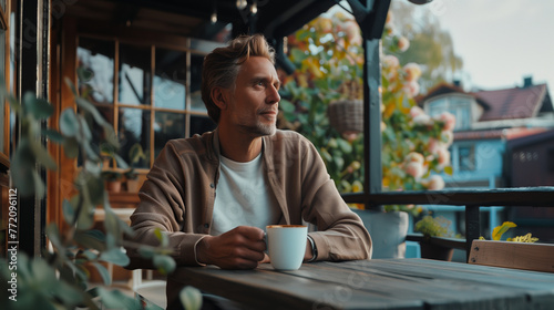 Man enjoying a cup of coffee on a cozy veranda, contemplating