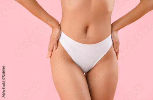 Beautiful young African-American woman with stretch marks on her body against pink background, closeup