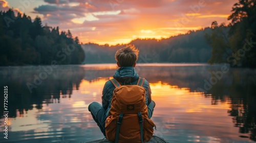 A person sitting on a log with backpack looking at the water, AI