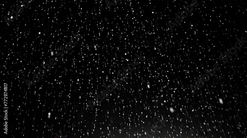 Snow falling against a dark background with a street light