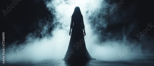  A woman in a lengthy black dress stands face-away from the camera in a misty location, her long hair billowing in the wind