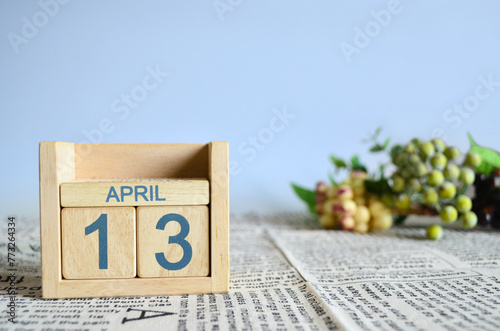 April 13, Calendar cover design with number cube with fruit on newspaper fabric and blue background. 