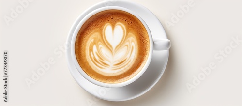 A ceramic cup filled with freshly brewed coffee, topped with a heart-shaped foam design, resting on a saucer