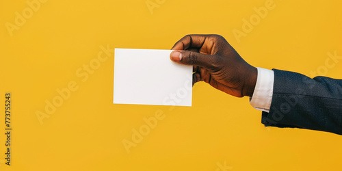 African American woman's hands presenting folded blank paper sheet or booklet, against pastel yellow background, Focus on crispness of paper and clean. Mock up adv advertisement concept