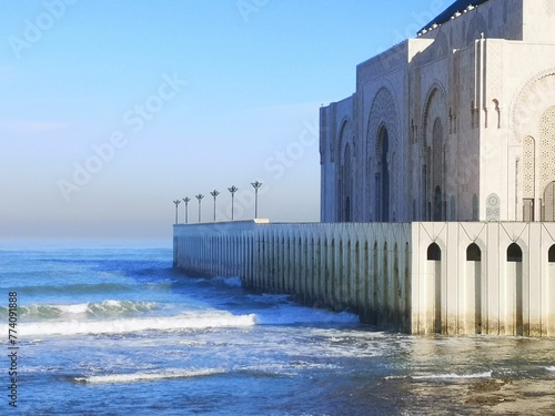 Exterior of Hassan II Mosque by the sea with blue sky in Casablanca, Morocco