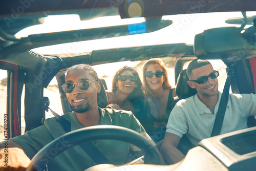 Young Couple With Friends On Vacation Inside Car Driving On Road Trip Adventure To Beach