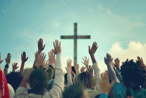 A diverse community of individuals with raised hands in worship towards a Christian cross
