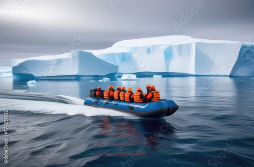 A group of people in orange vests on an inflatable blue boat floats among glaciers in the Atlantic. Global warming concept