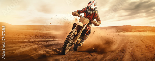 A motocross racer kicks up a cloud of dust as he races through a barren desert.