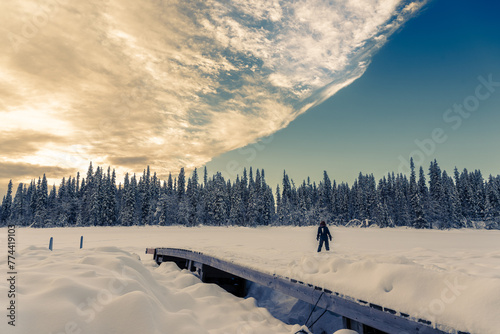Jeune femme devant une forêt et une étendue de neige au lever du soleil en Laponie en Suède