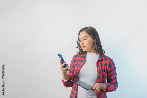 Mujer utilizando teléfono inteligente y tableta en un fondo blanco