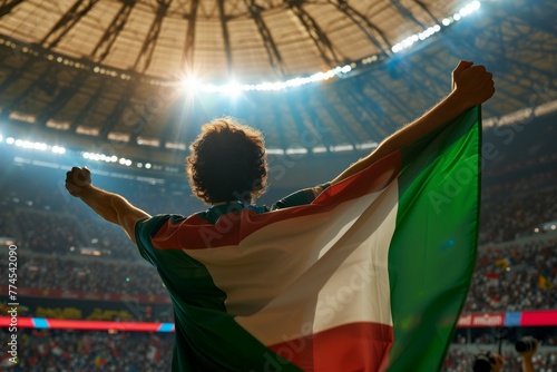 A man is holding a green and white flag in a stadium. Football fans at the European Football Championship