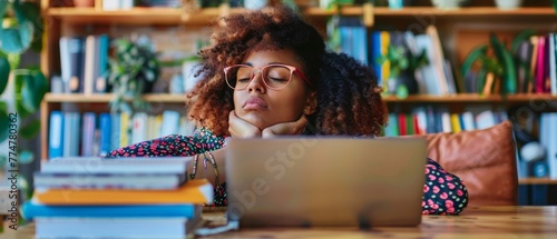 Woman working at office desk with laptop, her eyes are closing and she is about to fall asleep. Sleep deprivation and overtime working concept.