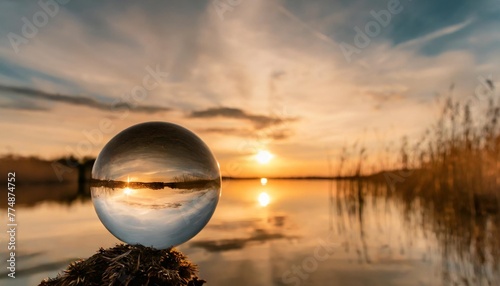 lensball sunset over the lake landscape beautiful silhouette sunrise sea colorful reed clouds sky sundown sun crystal ball background water concept summer