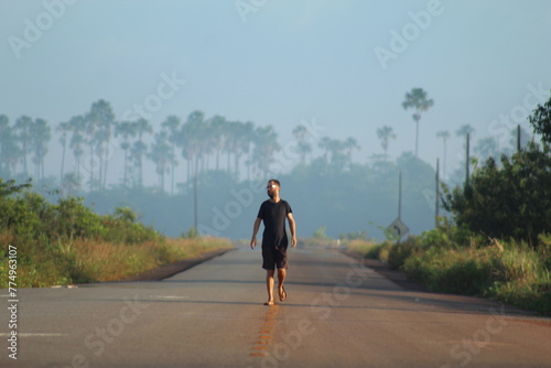 homem caminhando em rodovia em Calçoene, Amapá, em amanhecer com neblina 