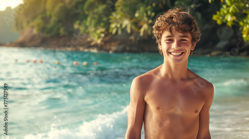 A smiling shirtless teenage boy on the tropical island background with copy space area, beautiful summer beach and turquoise sea