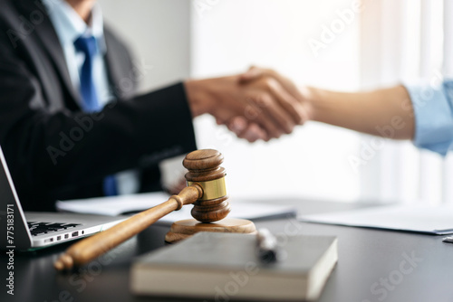 Handshake after good cooperation, Two people shaking hands after discussing contract agreement on front a judge's gavel