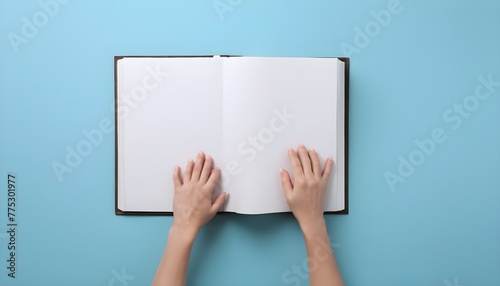 Woman with open photo album at light blue background, top view. Space for text