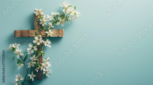A wooden cross with white flowers on a blue background. Suitable for religious and memorial themes