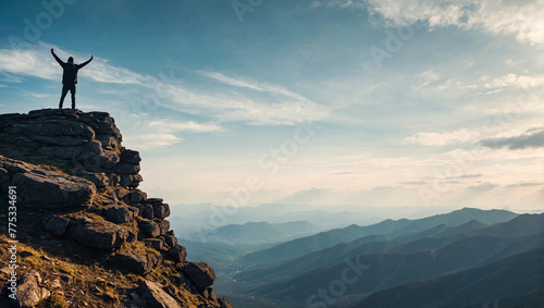 Silhouette of a lone person standing on top of a mountain arms outstretched to celebrate their success