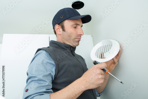 worker holding air filter for ventilation system