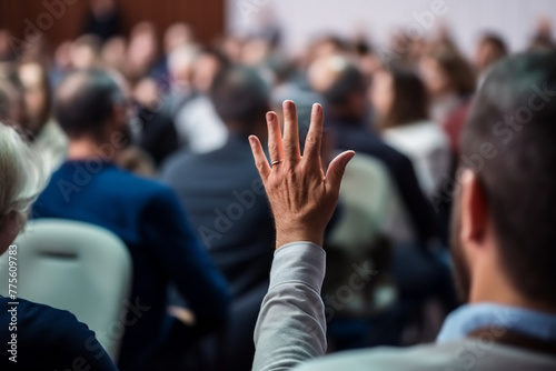 Engaged Audience Member Raising a Hand to Ask a Question During a Community Meeting