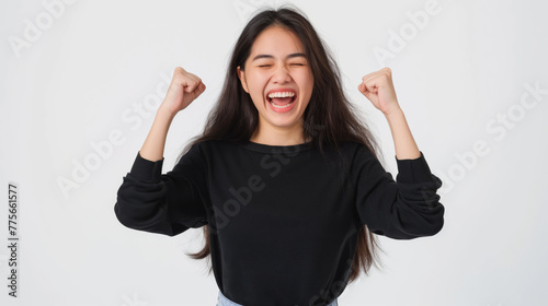 Joyful asian woman celebrating with a cheerful yes gesture