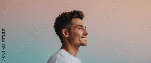 A man smiles softly at a gradient background