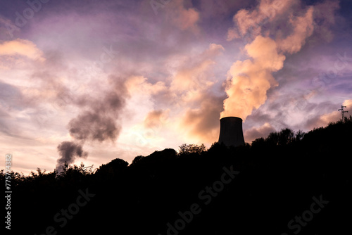 Silhouette of a cooling tower of a geothermal power plant at sunset, with pink-violet sky in Monterotondo Marittimo, near Larderello, in Tuscany, Italy