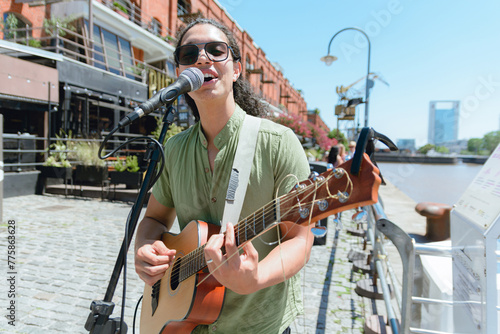 young guitarist on street making music playing and singing working on street in Buenos Aires