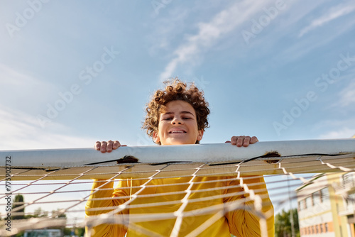 A peaceful moment captured as a young boy delicately holds a surfboard above a hammock, embodying the carefree spirit of summer by the beach.