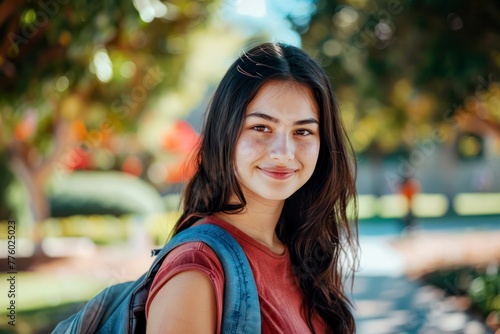 college student cute European 18 year old girl with backpack standing campus outside, smiling looking at the camera