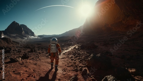 An astronaut in a vibrant orange suit hikes across a rocky Martian terrain, the horizon aglow with the light of a distant sun.