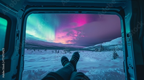 View from inside of a vintage camper van in wild snow field with beautiful aurora northern lights in night sky with snow forest in winter.